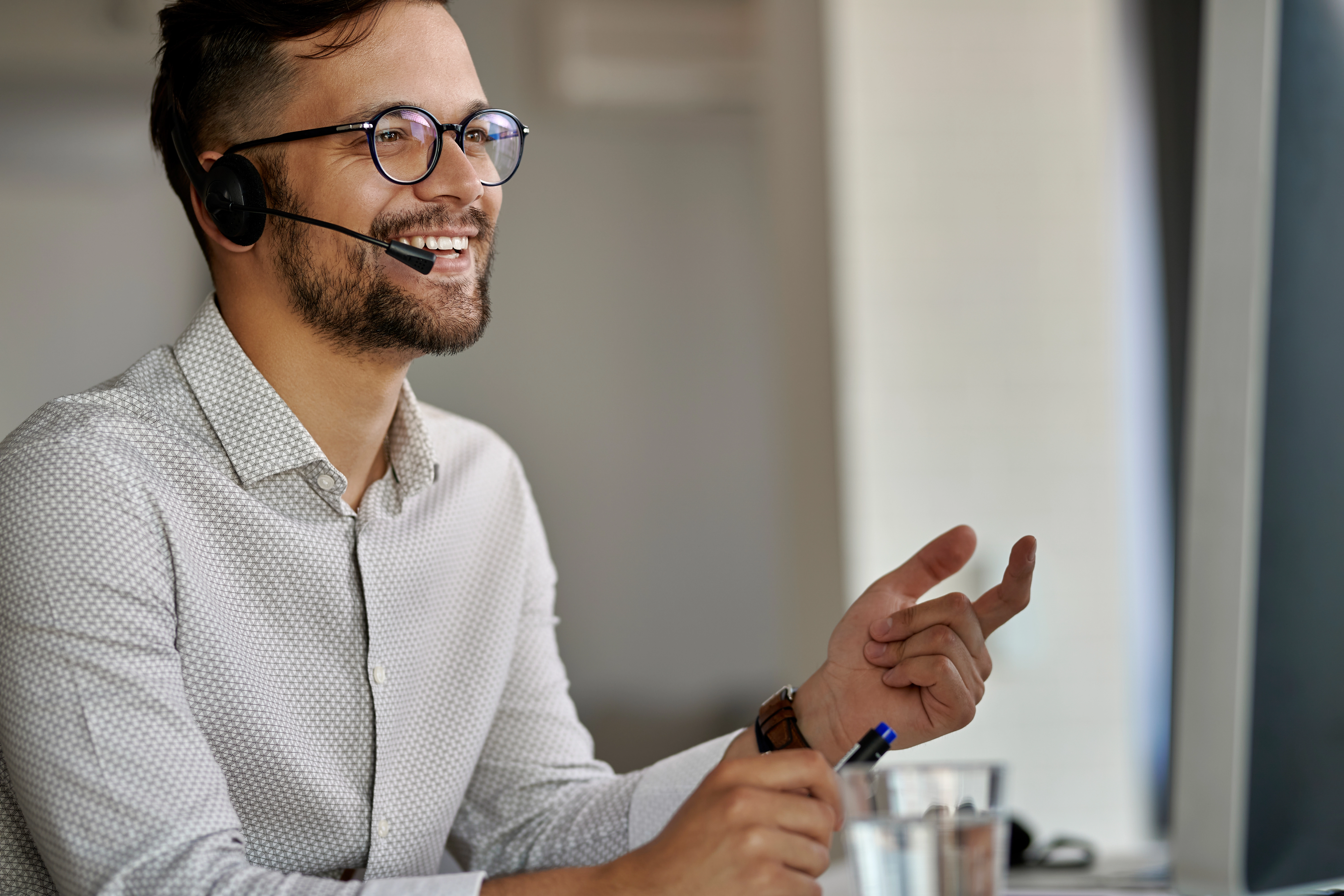 Call Center Mitarbeiter am PC kommuniziert am Telefon