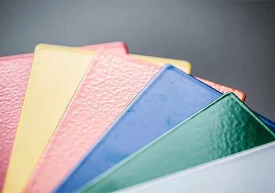 Detailaufnahme von mehreren Farbkarten, welche die Pulverbeschichtung zeigen Detailaufnahme von mehreren Farbkarten, welche die Pulverbeschichtung zeigen